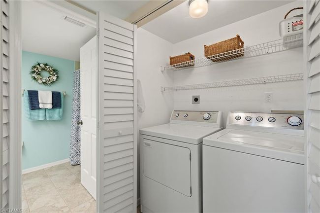 Clothes washing area featuring light tile patterned flooring and washer and dryer | Image 20