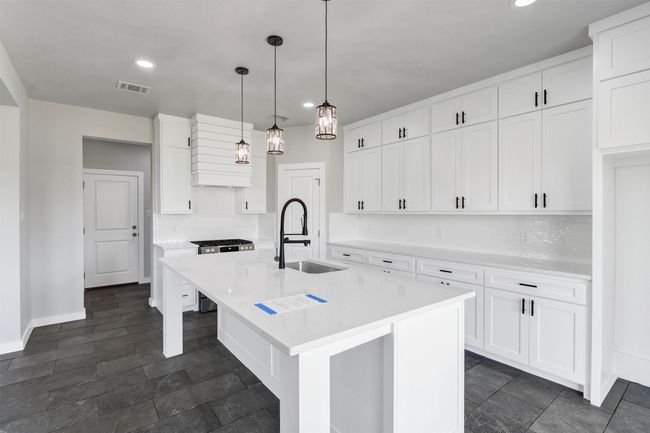Kitchen with a sink, recessed lighting, light countertops, white cabinets, and a kitchen island with sink | Image 15
