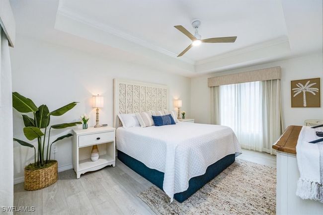 Primary Bedroom with king bed, tray ceiling and ceiling fan | Image 11