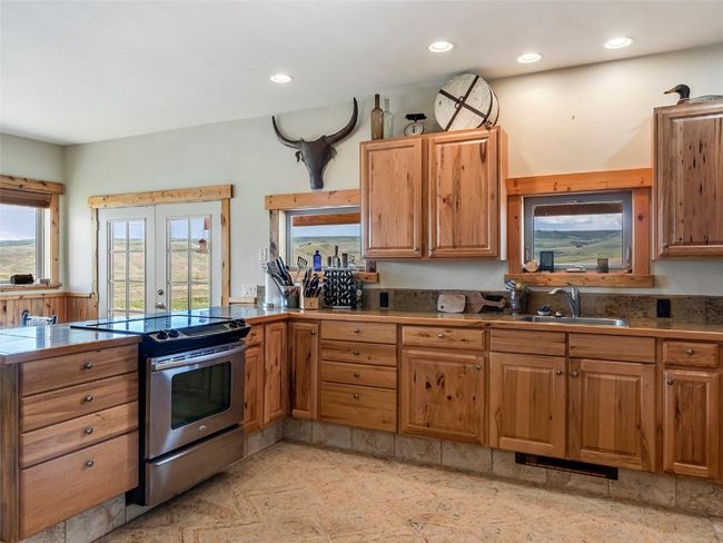 Kitchen with sink, french doors, electric range, and light tile patterned floors | Image 22
