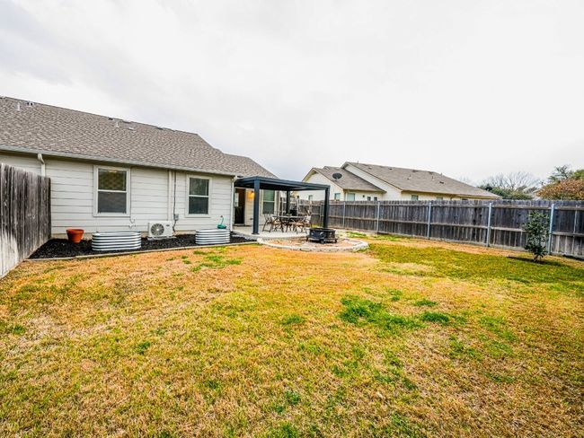 Back of house with a fenced backyard, a patio, and a lawn | Image 8
