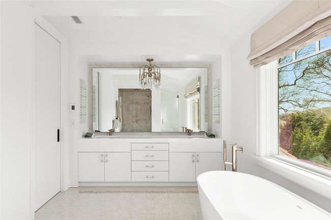 Full bathroom featuring double vanities, freestanding bath, shower, water closet and radiant flooring | Image 21