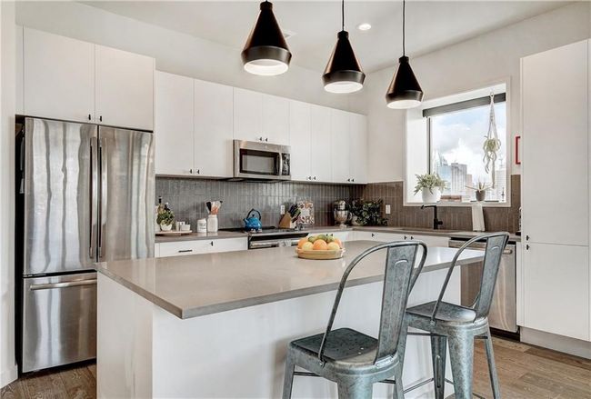 Chef's kitchen features quartz countertops, stainless steel appliances, smooth finish cabinetry and a spacious island with overhanging counter making entertaining effortless. | Image 7