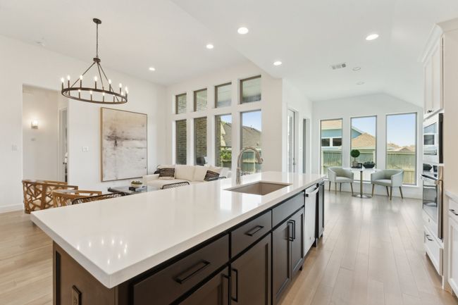 Kitchen featuring a sink, stainless steel oven, light countertops, light wood-style flooring, and recessed lighting | Image 10