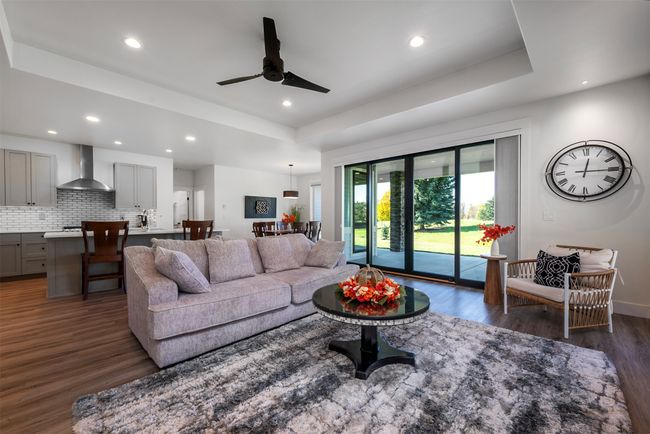Living room featuring ceiling fan and a raised ceiling | Image 9