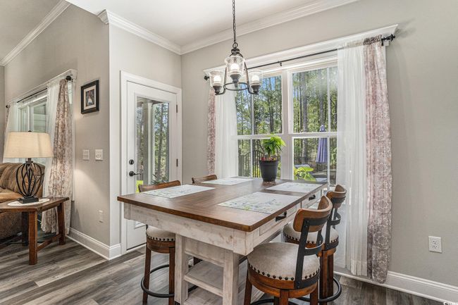 Dining space featuring dark wood-style floors, a chandelier, baseboards, and ornamental molding | Image 13