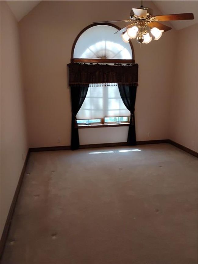 Upstairs bedroom #2 with lofted ceiling, light carpet, a ceiling fan, and oak baseboards | Image 74