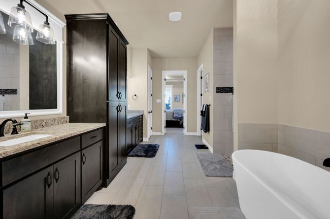 Full bath with ensuite bath, a freestanding bath, vanity, and tile patterned flooring | Image 19