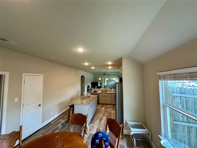 Dining room featuring wood finished floors, arched walkways, vaulted ceiling, and recessed lighting | Image 17