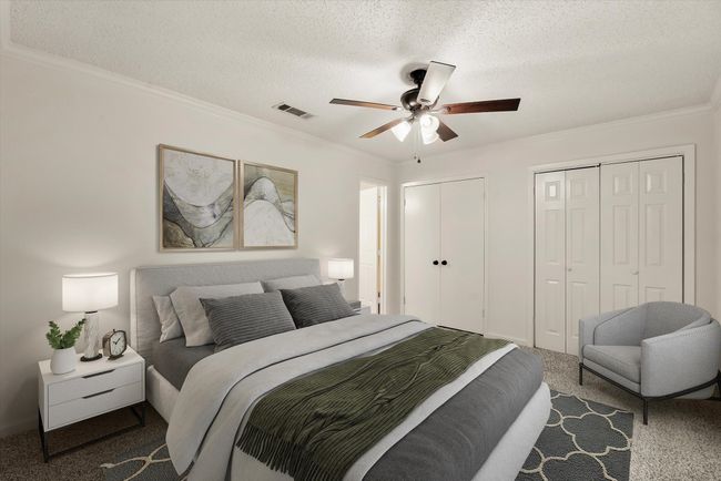 Bedroom featuring crown molding, carpet floors, two closets, and a textured ceiling | Image 18
