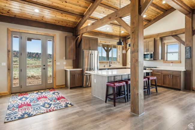 Kitchen with a sink, wooden ceiling, stainless steel appliances, a breakfast bar area, and light countertops | Image 34