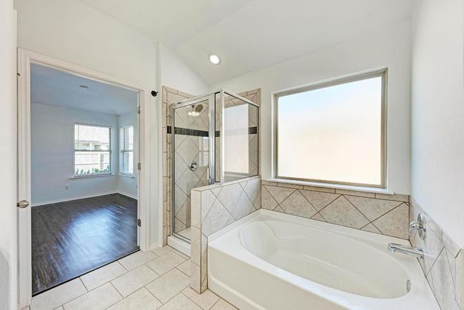 Bathroom featuring a stall shower, a garden tub, tile patterned flooring, and vaulted ceiling | Image 24