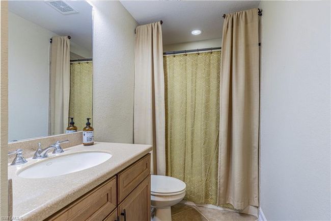 Bathroom with tile patterned flooring, toilet, vanity, and visible vents | Image 24