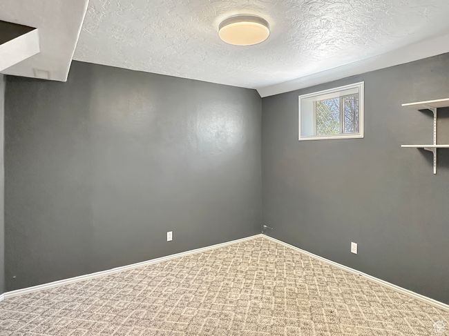 Empty room featuring a textured ceiling, carpet, and baseboards | Image 23