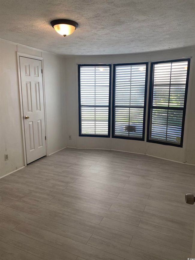 Empty room featuring a textured ceiling, plenty of natural light, and wood finished floors | Image 17