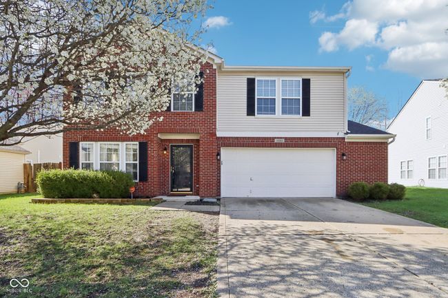 traditional-style home featuring an attached garage, driveway, brick siding, and a front lawn | Image 6