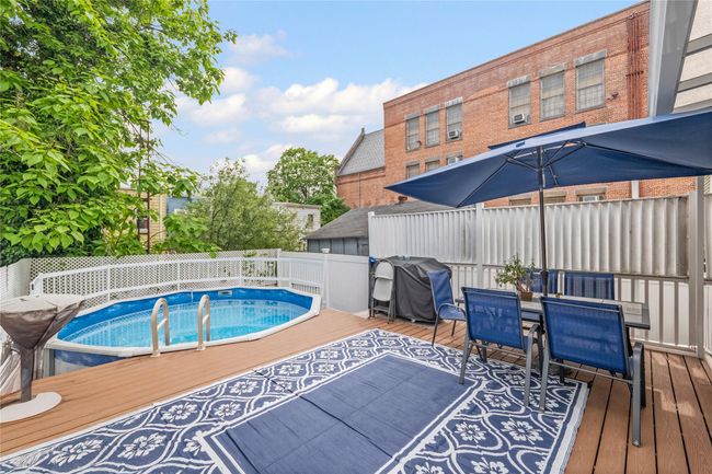 View of swimming pool with outdoor dining space, grilling area, a fenced backyard, and a deck | Image 31
