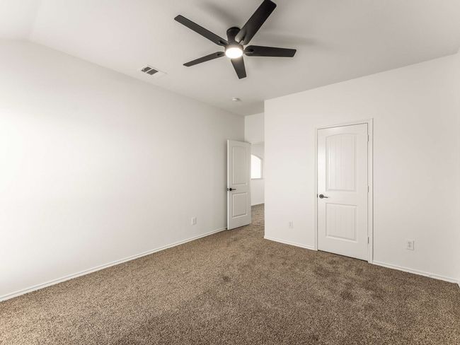 Unfurnished bedroom with carpet, a ceiling fan, and lofted ceiling | Image 33