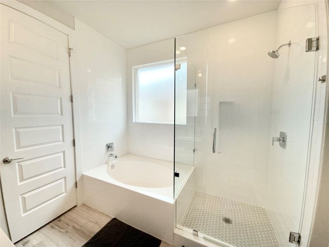 Bathroom with a stall shower, a bath, and wood finished floors | Image 22