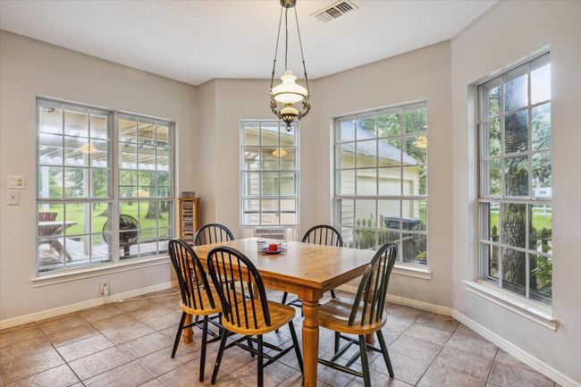 Charming two-story home with a welcoming front porch, nestled among mature trees. Features dormer windows, a classic gable roof, and a spacious yard, perfect for enjoying nature and outdoor activities. | Image 6
