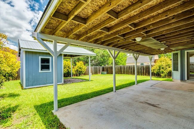 Backyard features storage shed with covered patio | Image 34