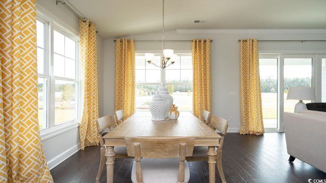 Dining space featuring a healthy amount of sunlight, an inviting chandelier, visible vents, and lofted ceiling | Image 17