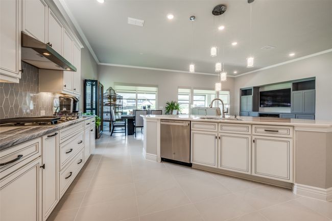 Kitchen with pendant lighting, light tile patterned floors, appliances with stainless steel finishes, tasteful backsplash, and sink | Image 9