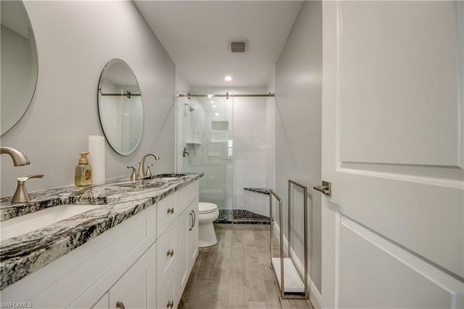 Bathroom featuring walk in shower, vanity, and toilet | Image 8
