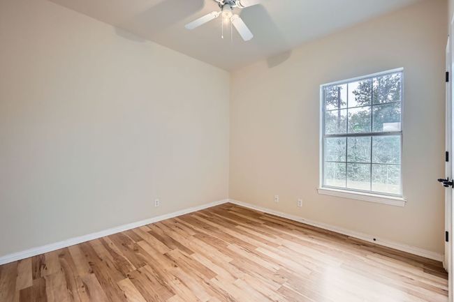 Spare room with light wood-style flooring, baseboards, and a ceiling fan | Image 14