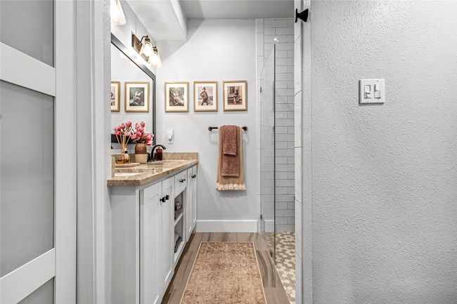 Bathroom featuring vanity, tiled shower, and wood finished floors | Image 15
