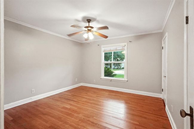 Office space featuring ornamental molding, baseboards, light wood finished floors, and a ceiling fan | Image 22