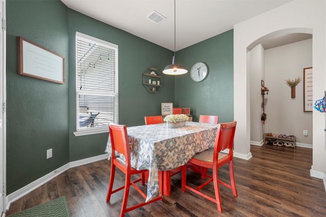 Dining room with arched walkways and dark wood-style flooring | Image 8