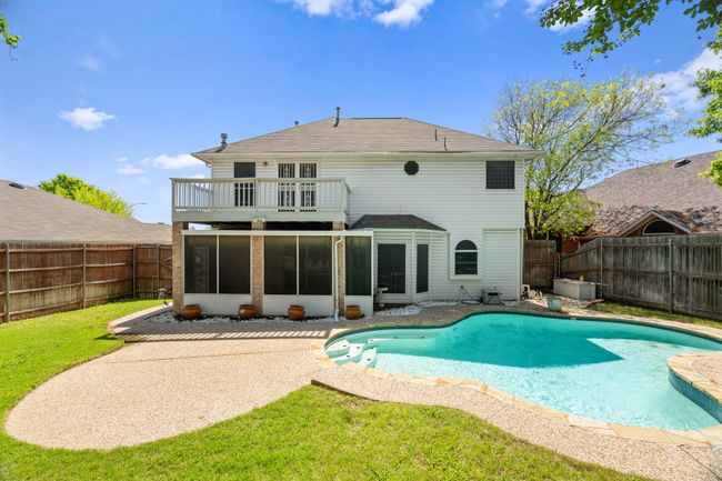 Rear view of property with a fenced in pool, a fenced backyard, a sunroom, and a lawn | Image 32