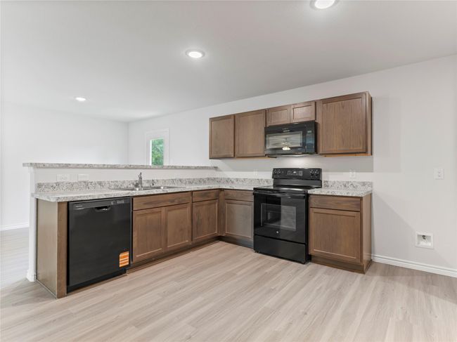 Sleek new black appliances enhance the modern kitchen. | Image 7
