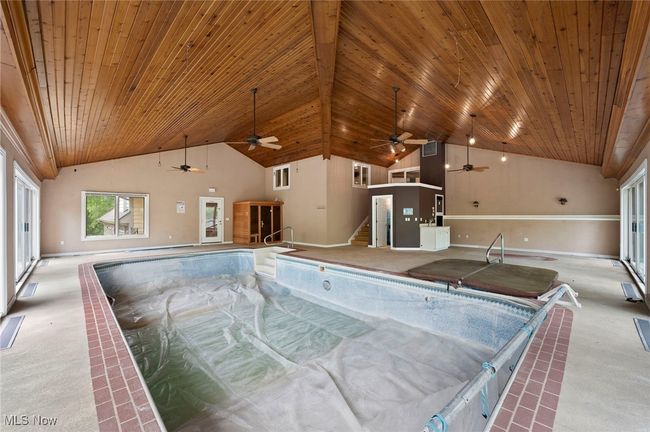 Indoor pool featuring a hot tub and ceiling fan | Image 35