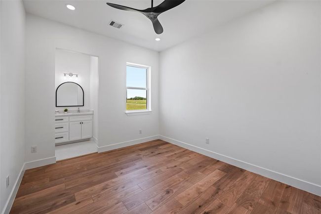 Spacious second bedroom featuring natural light, sleek LVP floors, and an en-suite bathroom. | Image 38