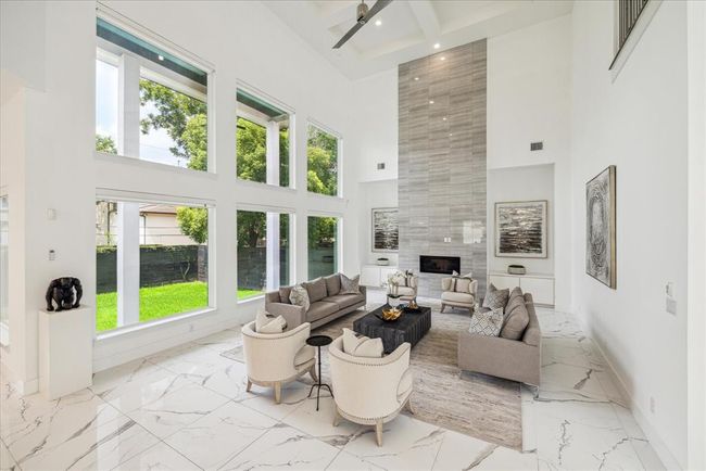 FAMILY ROOM: The heart of this modern home, where the family room combines comfort, style, and breathtaking views. A wall of expansive windows stretches across one side of the room, flooding the space with natural light and offering panoramic views of the surrounding landscape. | Image 9