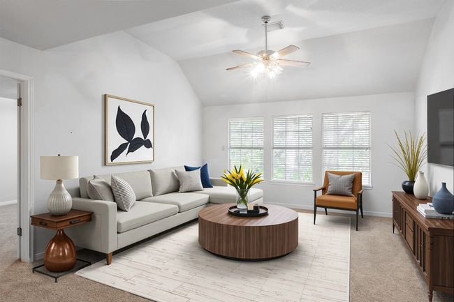 Living room with vaulted ceiling, light carpet, a ceiling fan, and baseboards | Image 9