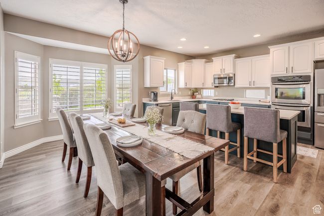Dining area with light wood-style floors, recessed lighting, a notable chandelier, and baseboards | Image 7