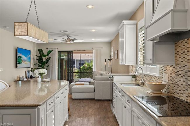 Kitchen featuring white cabinets, decorative light fixtures, and sink | Image 12