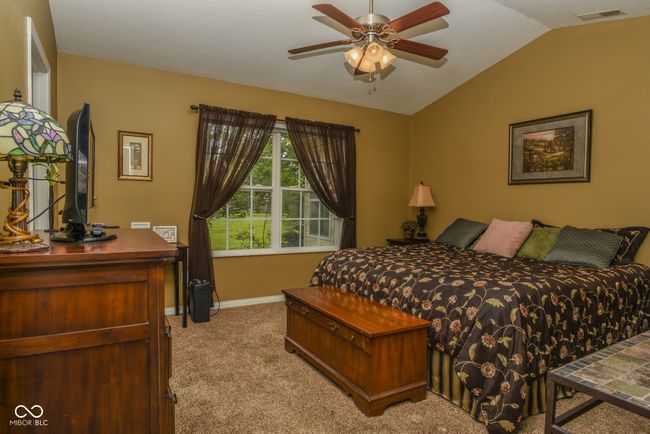bedroom featuring light colored carpet, lofted ceiling, and baseboards | Image 9