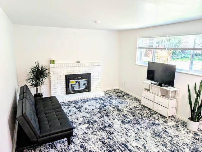 Carpeted living area featuring plenty of natural light and a brick fireplace | Image 9
