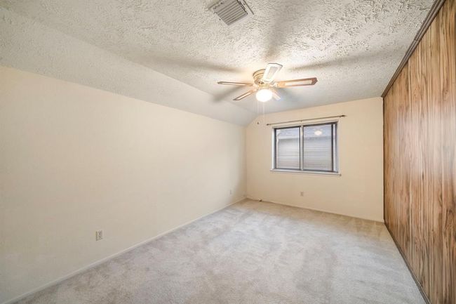 Spacious secondary bedroom features vaulted ceilings, neutral carpet, and a large window for ample natural light. | Image 25