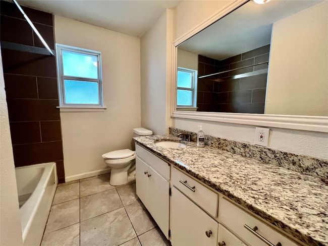 Full bath featuring vanity, toilet, plenty of natural light, and tile patterned flooring | Image 16