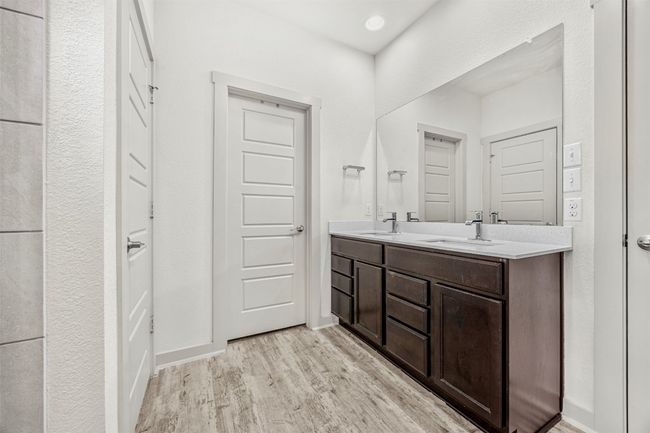 A closer look at the primary bathroom's dual-sink vanity and expansive mirror, providing plenty of space for daily routines. | Image 17