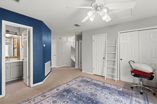 Carpeted office space featuring a sink, baseboards, ceiling fan, and visible vents | Image 16