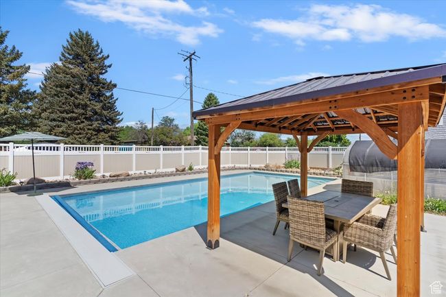 View of swimming pool with a gazebo, a patio area, a fenced backyard, and outdoor dining space | Image 32