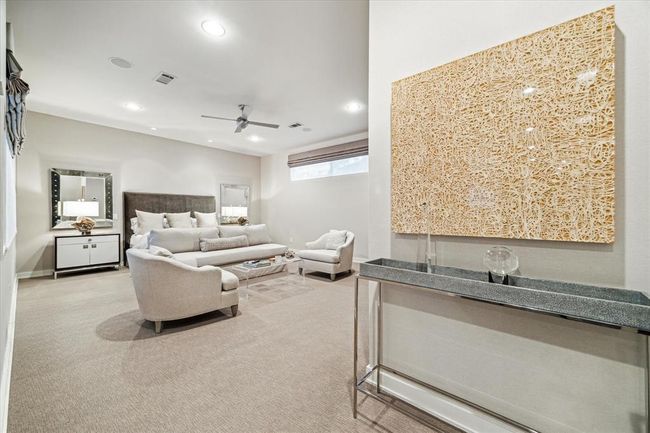 The grand PRIMARY SUITE (20 X 17) includes carpeted flooring, scenic window overlooking backyard with black out shades, raised horizontal privacy window with blackout shades, ceiling fan, ceiling speakers, painted walls, recessed lighting and base molding. | Image 21