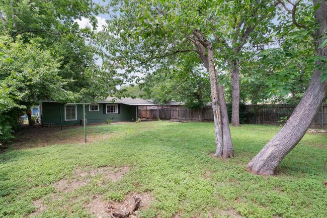 The backyard is filled with trees and lots of space, making it perfect for entertaining or sitting out and enjoying the outdoors. | Image 21