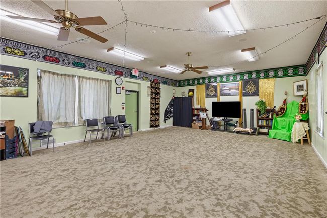 Rec room featuring baseboards, carpet floors, a textured ceiling, and a ceiling fan | Image 26